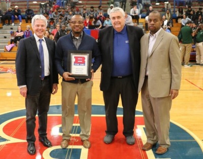 Harold Byrd standing with Bruce Smith and two other men at Bartlett High School in the gym.